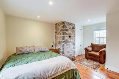 a bedroom with a bed and a stone wall at In-Town and Walkable Historic Yardley Retreat! in Yardley
