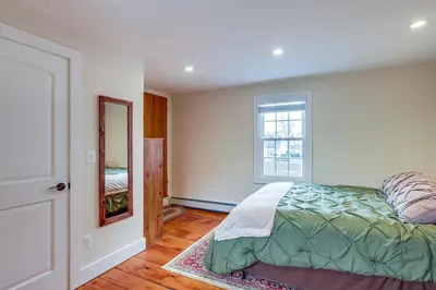 a bedroom with a bed and a window and a mirror at In-Town and Walkable Historic Yardley Retreat! in Yardley