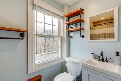 a bathroom with a toilet and a sink and a window at In-Town and Walkable Historic Yardley Retreat! in Yardley