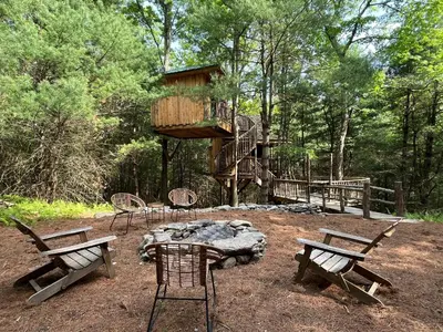 a tree house in the middle of a forest at Little Birds Treehouse in Sparrow Bush