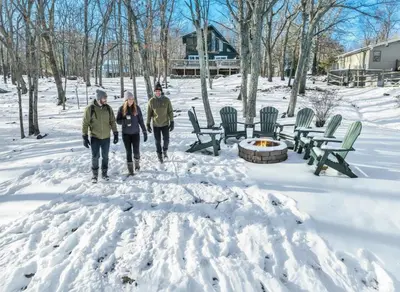 a group of three people walking through the snow at Lakefront, Hot Tub, Heated Pool, Beach, Free Boats in Bushkill