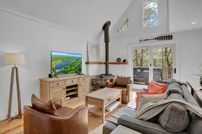 a living room with a couch and a tv at Lakefront, Hot Tub, Heated Pool, Beach, Free Boats in Bushkill