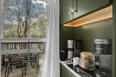 a kitchen with a balcony with a table and a window at Lakefront, Hot Tub, Heated Pool, Beach, Free Boats in Bushkill