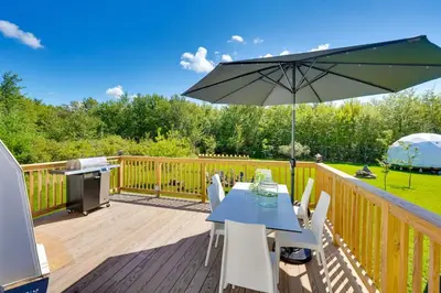 a wooden deck with a table and an umbrella at Unique Escapes - Modern Luxury Geodome in Monticello