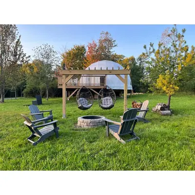 a group of chairs sitting in the grass with a gazebo at Unique Escapes - Modern Luxury Geodome in Monticello