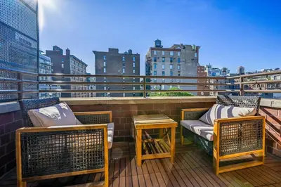 a balcony with two chairs and a table on a building at Modern one bedroom with private balcony in New York