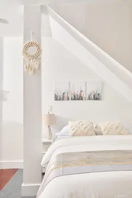 a bedroom with white walls and a white bed at Private Loft in Hells Kitchen near Times Square in New York