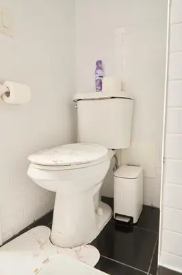 a bathroom with a toilet with a bottle on top at Private Loft in Hells Kitchen near Times Square in New York