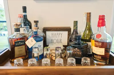 a group of alcohol bottles and glasses on a table at Modern Lodge on 6 acres - 15 mins to Camelback in Cresco