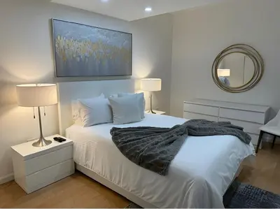 a bedroom with a white bed and a mirror at PlanURstay - Spacious Midtown West Fully-Serviced - 1BR & 1BTH in New York