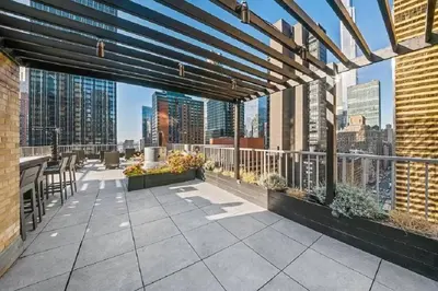 a rooftop patio with a view of the city at PlanURstay - Spacious Midtown West Fully-Serviced - 1BR & 1BTH in New York