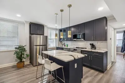 a kitchen with black cabinets and a stainless steel refrigerator at AF Stays - Philadelphia Callowhill in Philadelphia