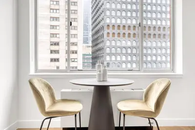 a table and two chairs in front of a window at FiDi 2br w wd doorman elevator roof NYC-772 in New York