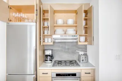 a kitchen with a stove and a refrigerator at FiDi 2br w wd doorman elevator roof NYC-772 in New York