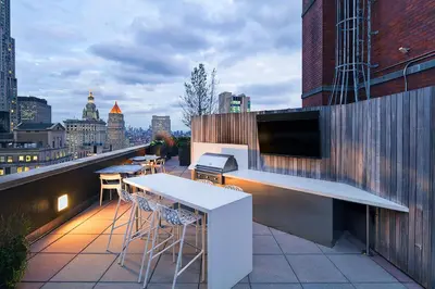 a balcony with a bar and stools on a building at FiDi 2br w wd doorman elevator roof NYC-772 in New York