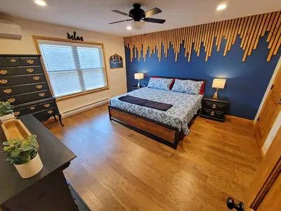 a bedroom with a bed and a blue wall at Swept Away Chalet - Luxurious NEW 6 BR Home Sleeps 16 Hot Tub Linens and Towels in Albrightsville