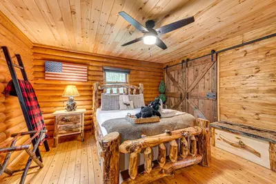 a bedroom with a bed in a log cabin at Game Room, Hot Tub! Cabin 9 Mi to Big Boulder Mtn in Albrightsville