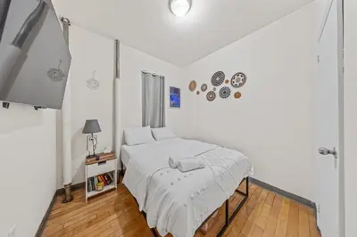 a white bedroom with a bed and a window at Steps from Everything - Modern 1-Bdr in Downtown's Union Square in New York