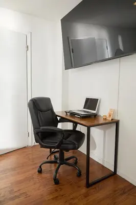 a desk with a chair and a laptop on it at American Dream Guest House in New York