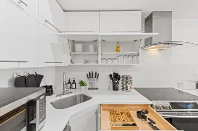 a kitchen with white cabinets and a sink at Elegant Urban Retreat in the Heart of Center City in Philadelphia