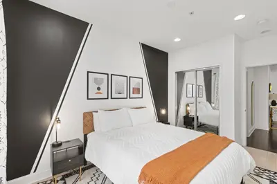 a bedroom with a large bed and a large mirror at Elegant Urban Retreat in the Heart of Center City in Philadelphia