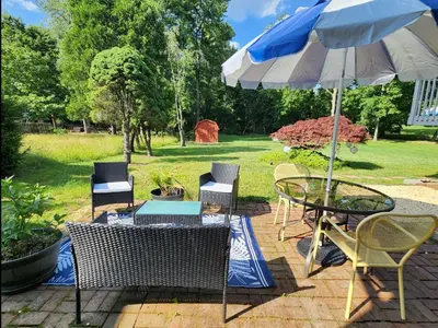 a patio with a table and chairs and an umbrella at Chic Spacious Apt Near Attractions/Food/EWR/NYC in West Orange