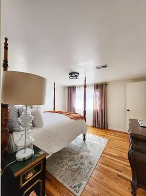 a bedroom with a bed and a lamp on a table at Chic Spacious Apt Near Attractions/Food/EWR/NYC in West Orange