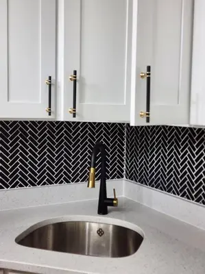 a sink in a kitchen with black and white tile at Chic Spacious Apt Near Attractions/Food/EWR/NYC in West Orange
