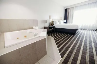 a hotel room with a tub and a bed at Parkview Inn & Suites, Lancaster Amish Country, PA in Lancaster