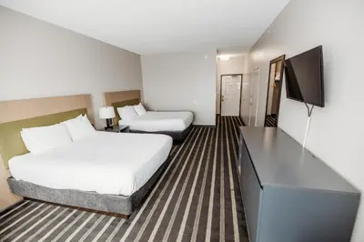 a hotel room with two beds and a flat screen tv at Parkview Inn & Suites, Lancaster Amish Country, PA in Lancaster