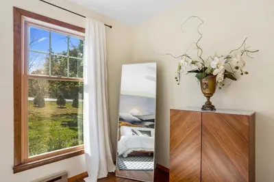 a mirror and a dresser in a room with a window at Catskills Delaware River Modern Colonial Getaway in Narrowsburg