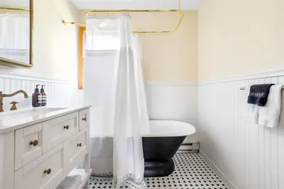 a bathroom with a black and white shower curtain at Catskills Delaware River Modern Colonial Getaway in Narrowsburg