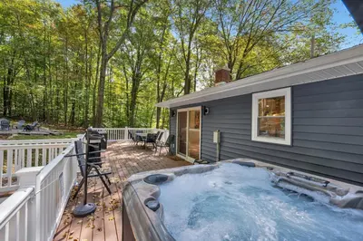 a hot tub on a deck next to a house at Lakeside, Dock, Hot Tub, Kayaks, Arcade, Playset in Lake Ariel