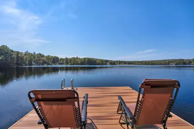 two chairs sitting on a dock on a lake at Lakeside, Dock, Hot Tub, Kayaks, Arcade, Playset in Lake Ariel