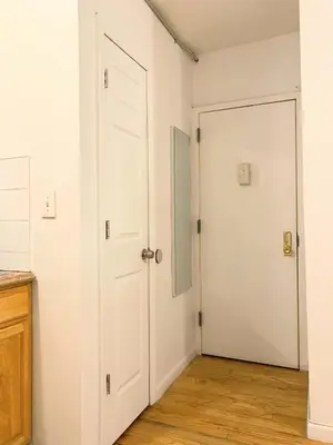 two white doors in a room with wood floors at Shered bathroom 4 SofaBed + loftbed + kitchen in New York