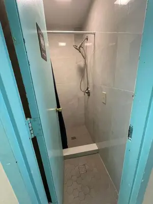a bathroom with a shower with a glass door at Shered bathroom 4 SofaBed + loftbed + kitchen in New York