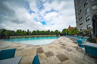 a large swimming pool with blue chairs next to a building at Avenue B946 City Urban Retreat, 2Br, Free Parking in Philadelphia