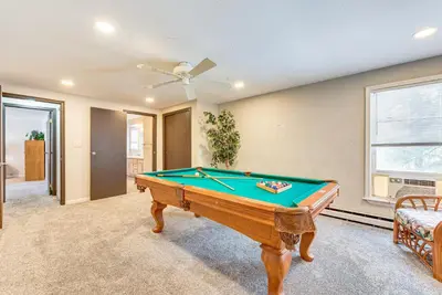 a pool table in a living room with a ceiling fan at Arrowhead Lake Retreat with Private Indoor Pool! in Pocono Lake