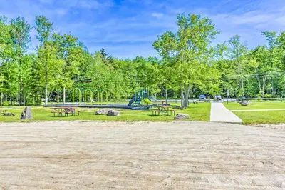 a park with picnic tables and a playground at Arrowhead Lake Retreat with Private Indoor Pool! in Pocono Lake