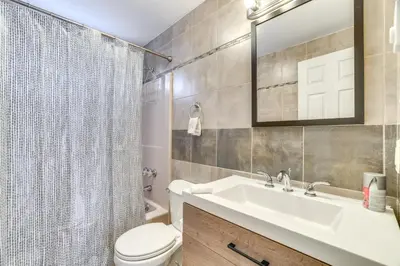 a bathroom with a sink and a toilet and a mirror at Game Room and Pool Access Pocono Paradise Haven in Tobyhanna