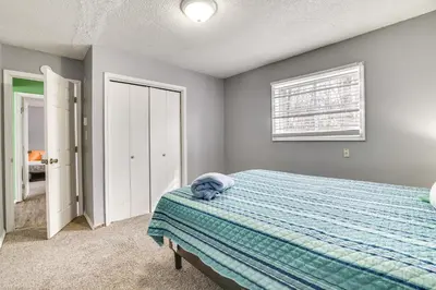 a bedroom with a bed with a blue blanket at Game Room and Pool Access Pocono Paradise Haven in Tobyhanna