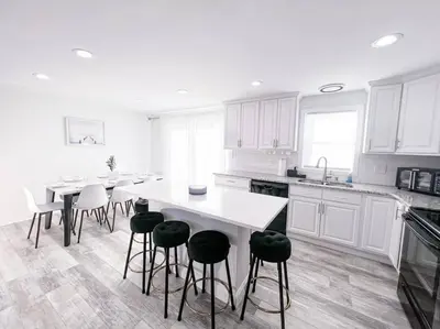 a kitchen with white cabinets and a white table and stools at Cozy Getaway Lodge & Retreat in Mechanicsburg