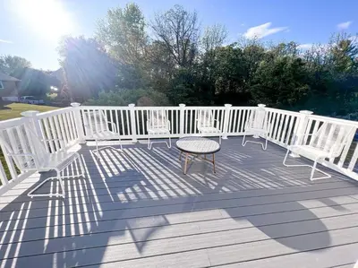 a deck with white chairs and a table on it at Cozy Getaway Lodge & Retreat in Mechanicsburg