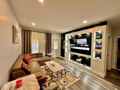 a living room with a couch and a flat screen tv at The Stylish Suite - 1BR with Free Parking in Paterson