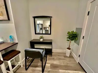 a hallway with a mirror and a table and a chair at The Stylish Suite - 1BR with Free Parking in Paterson
