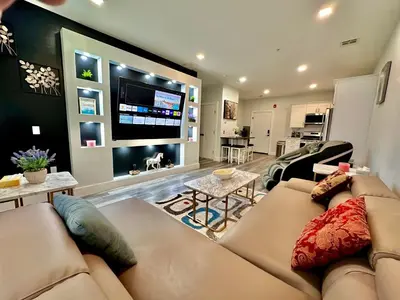 a living room with a couch and a flat screen tv at The Stylish Suite - 1BR with Free Parking in Paterson
