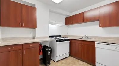 a kitchen with wooden cabinets and a white stove top oven at PP 1203 Corporate 1br, Pool, Free Parking, Gym in Harrisburg