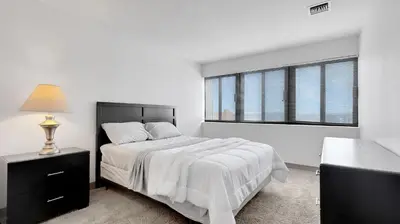 a white bedroom with a bed and a window at PP 1203 Corporate 1br, Pool, Free Parking, Gym in Harrisburg