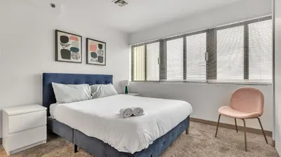 a bedroom with a large bed and a pink chair at PP 1801 Modern Corporate 2br, pool, Gym in Harrisburg