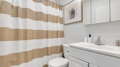 a bathroom with a white toilet and a sink at PP 514 City Chic in a Modern Studio Haven in Harrisburg